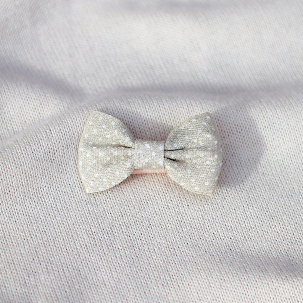 Polka dot bow on a light gray fabric background