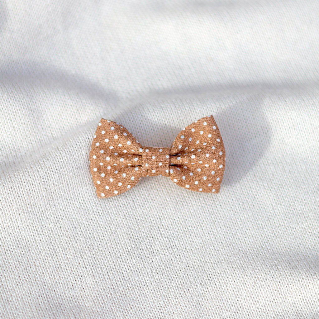 Polka dot bow tie on a white fabric background