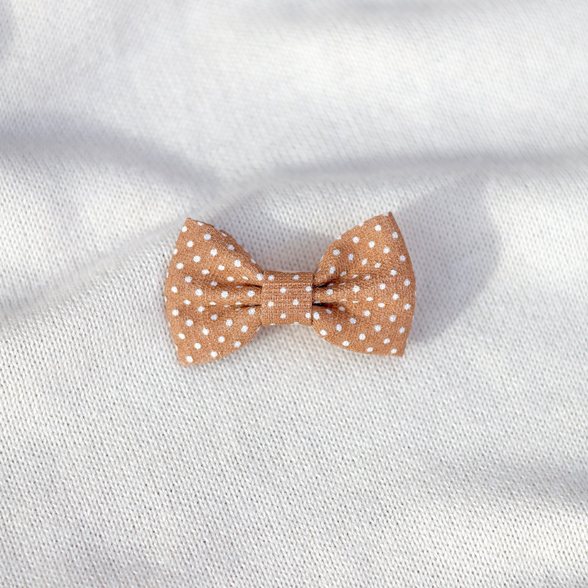 Polka dot bow tie on a white fabric background