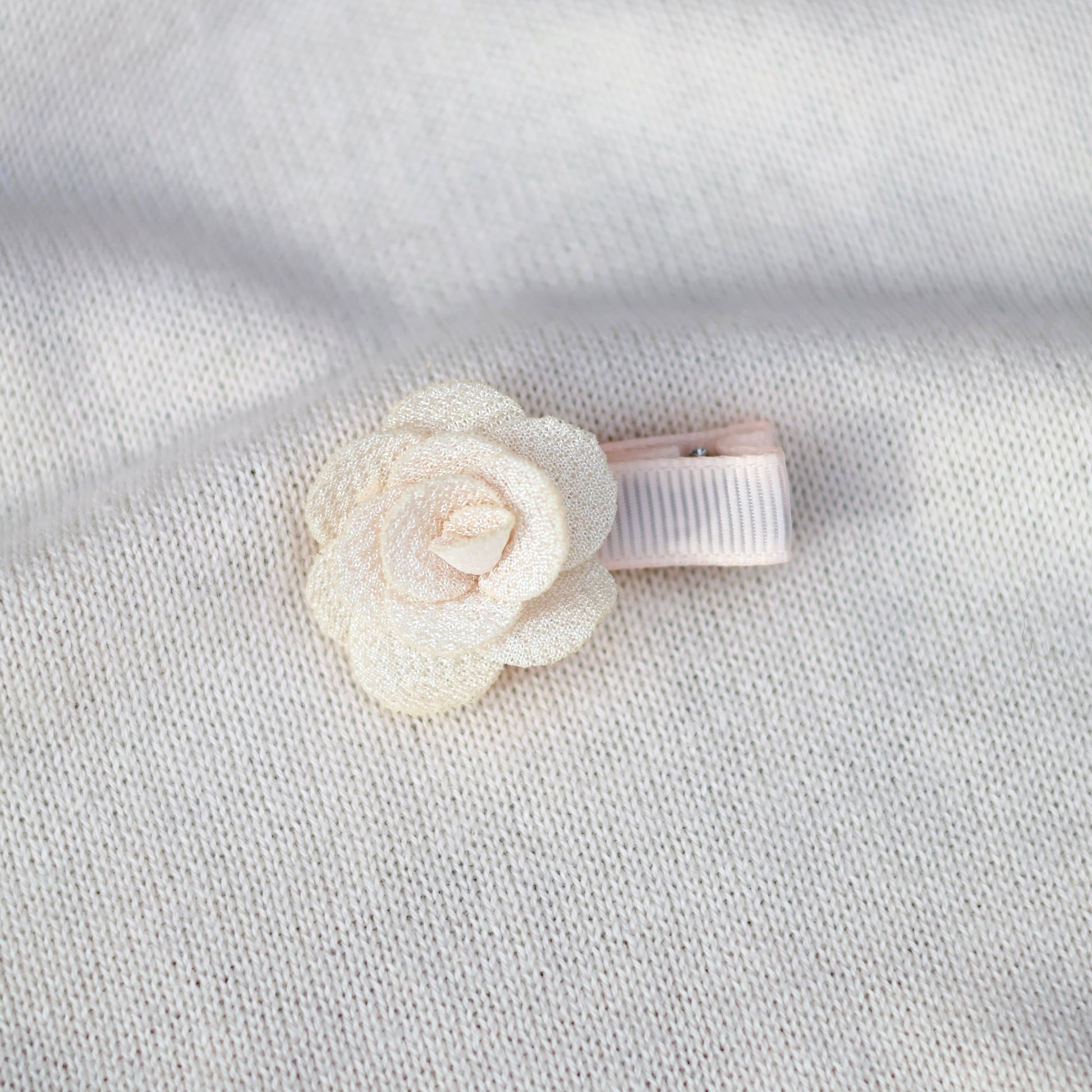 Floral hair clip on a textured light gray background