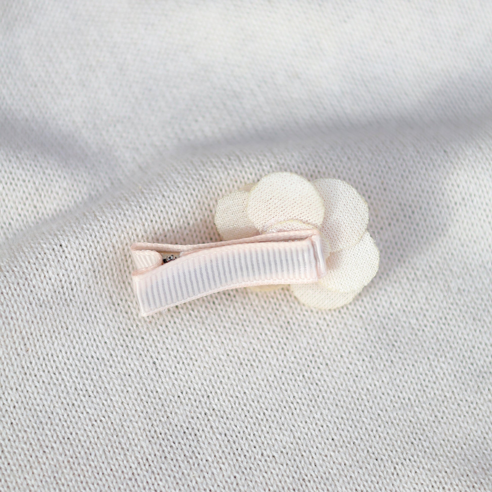 White hair clip on a textured light gray background