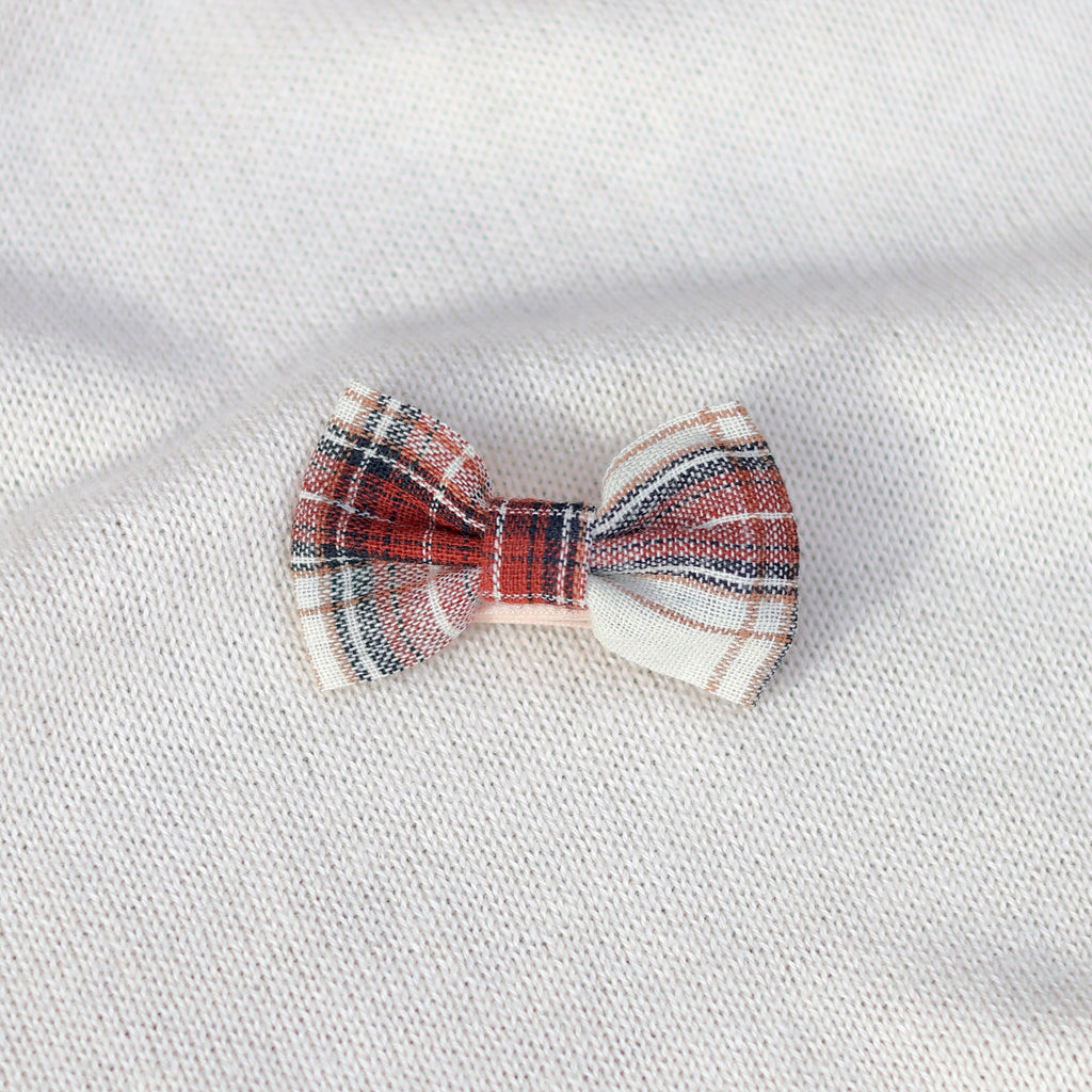 Plaid bow tie on a white fabric background
