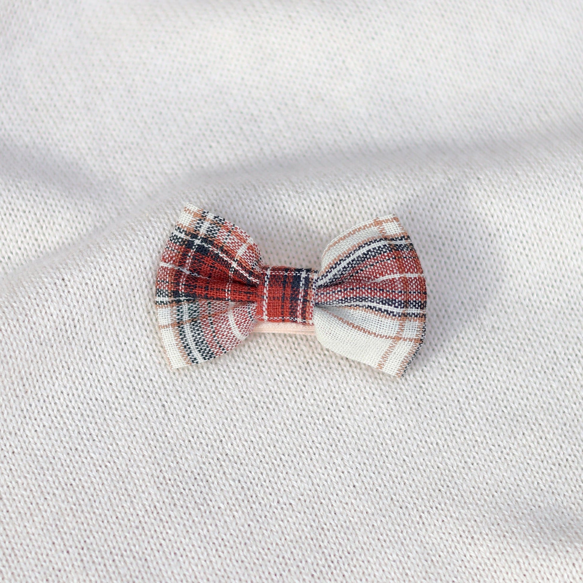Plaid bow tie on a white fabric background