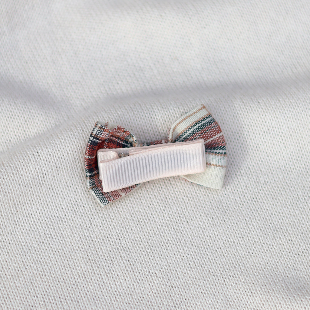 Striped hair clip on a textured white fabric background
