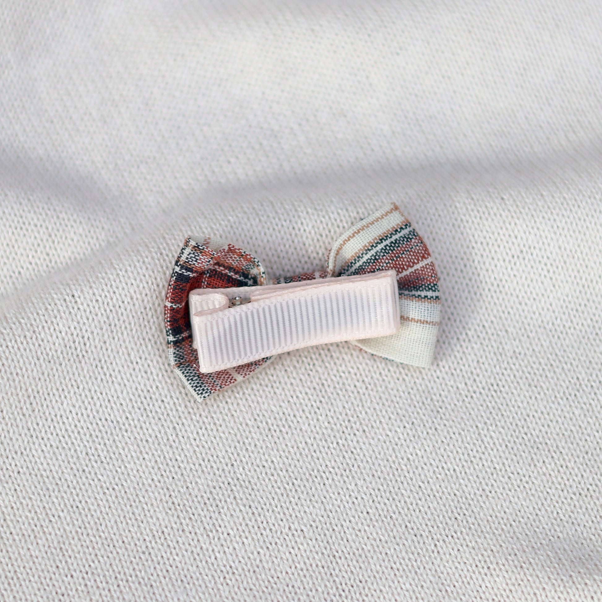 Striped hair clip on a textured white fabric background