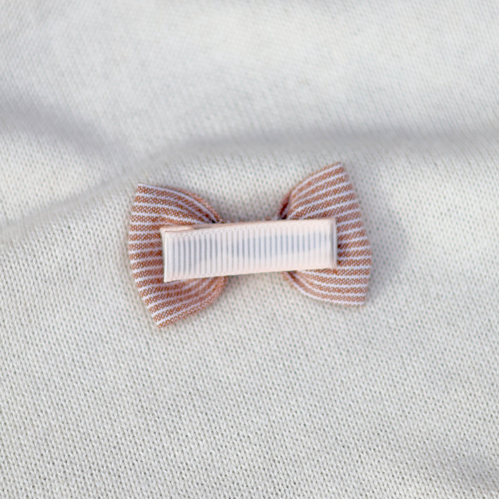 Hair clip with striped design on a textured white background