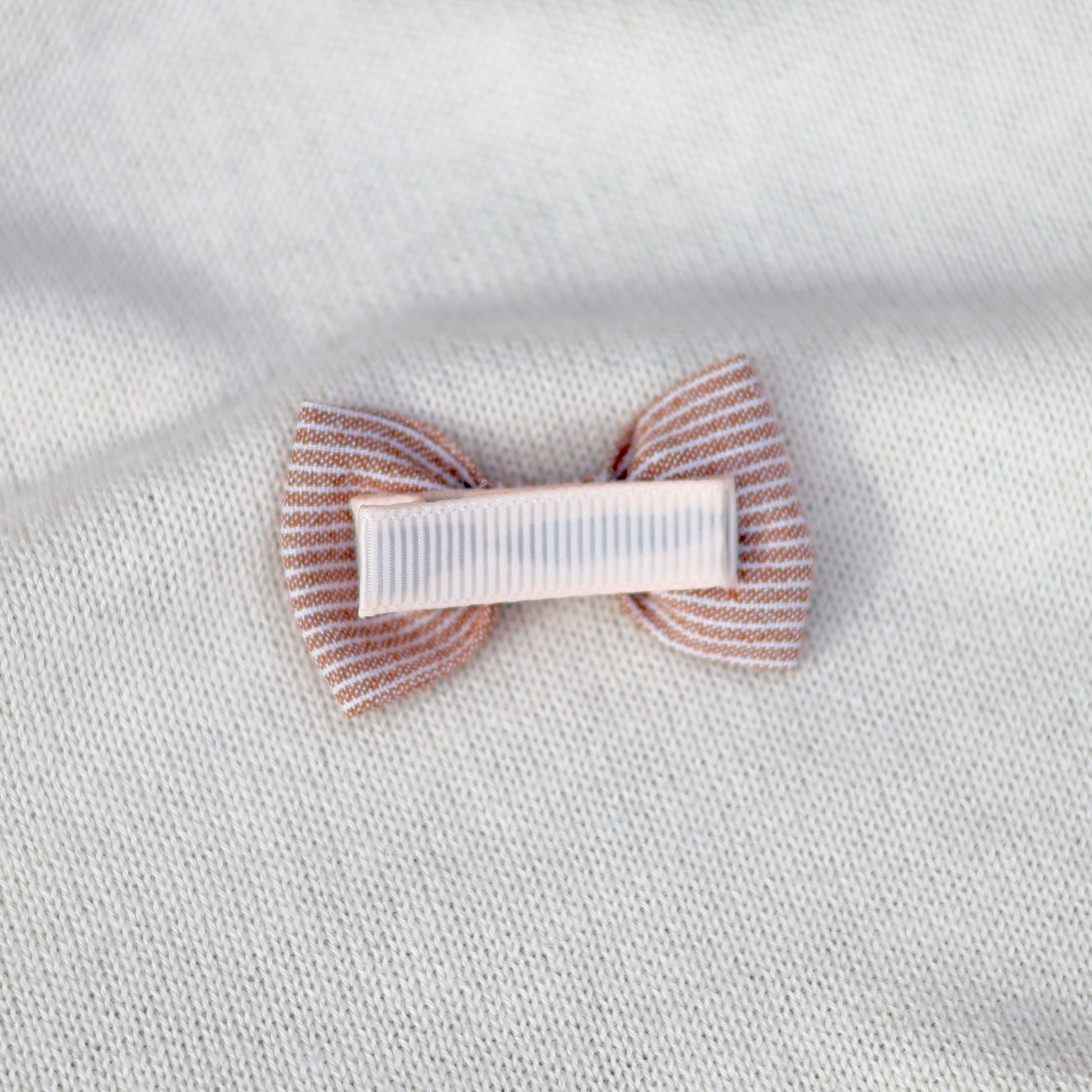 Hair clip with striped design on a textured white background