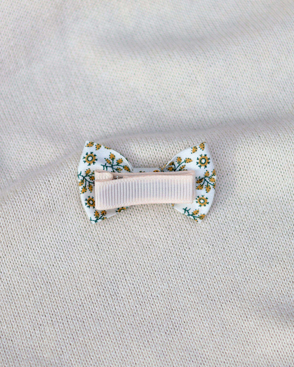 Floral hair clip on a textured light gray background