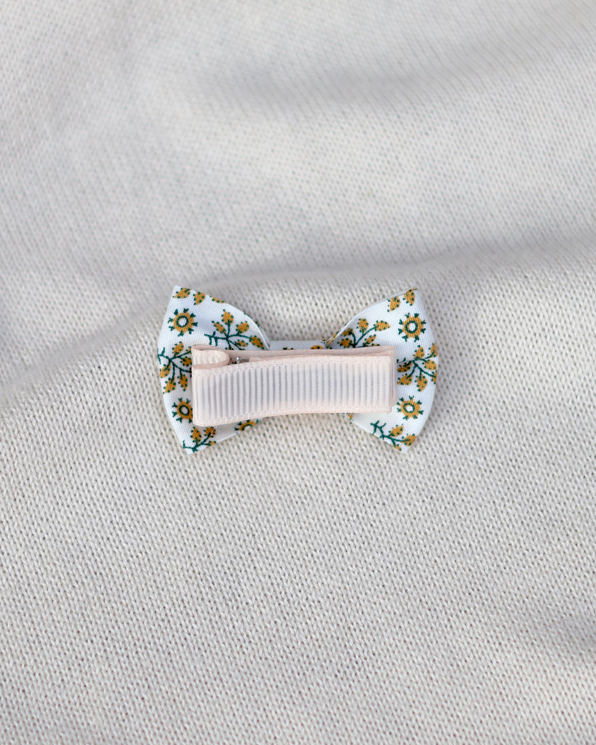 Floral hair clip on a textured light gray background