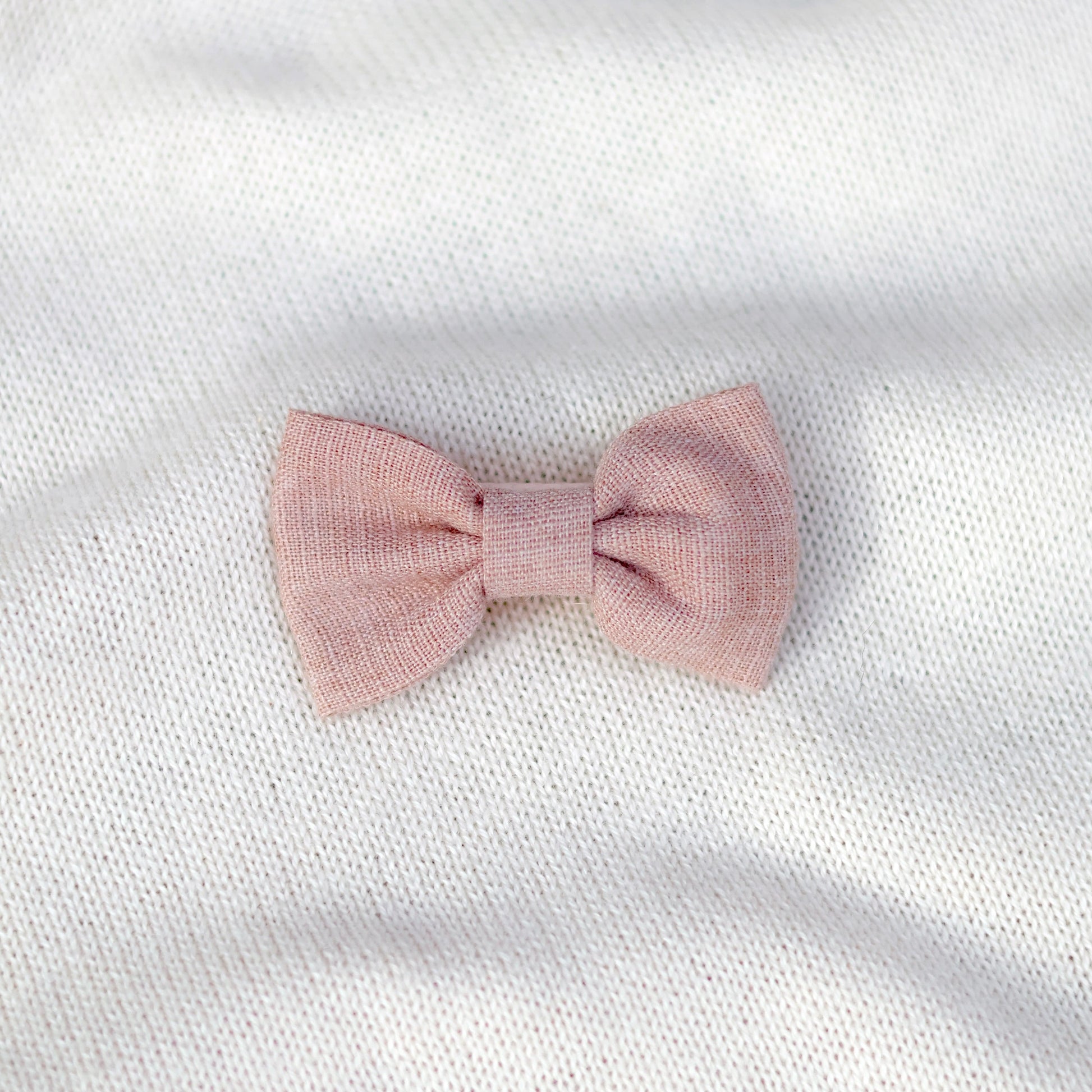 Pink bow on a white textured background