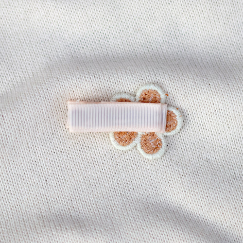 White fabric with a small white label and brown paw prints on a light gray background