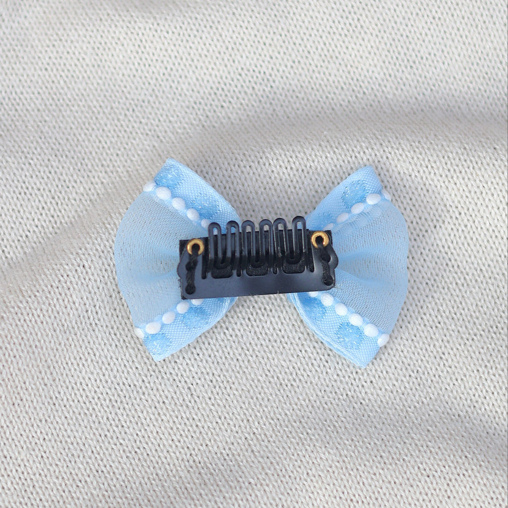 Blue bow hair clip on a light gray fabric background