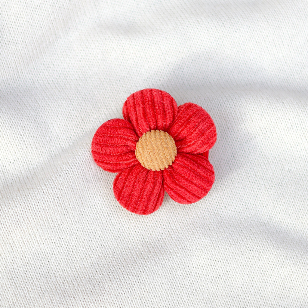 Red flower-shaped object on a white fabric background