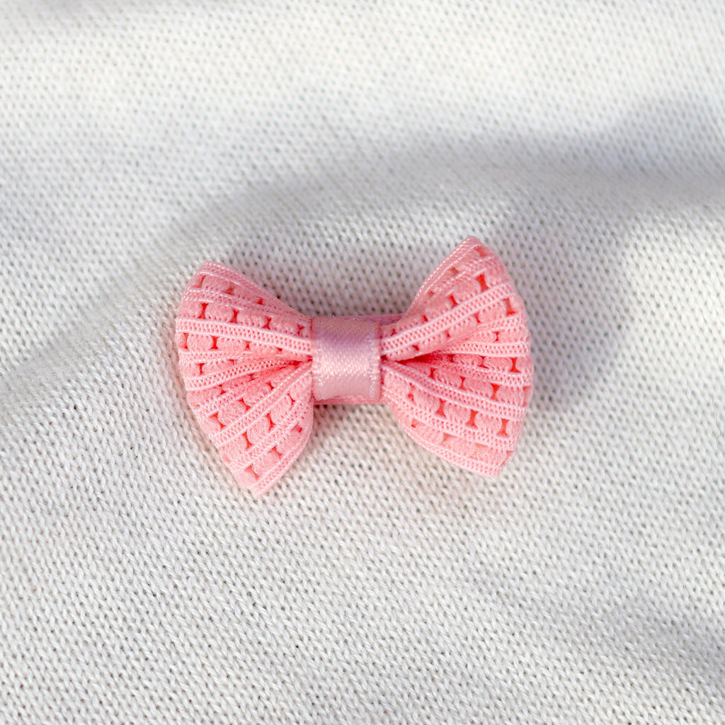 Pink bow on a white fabric background