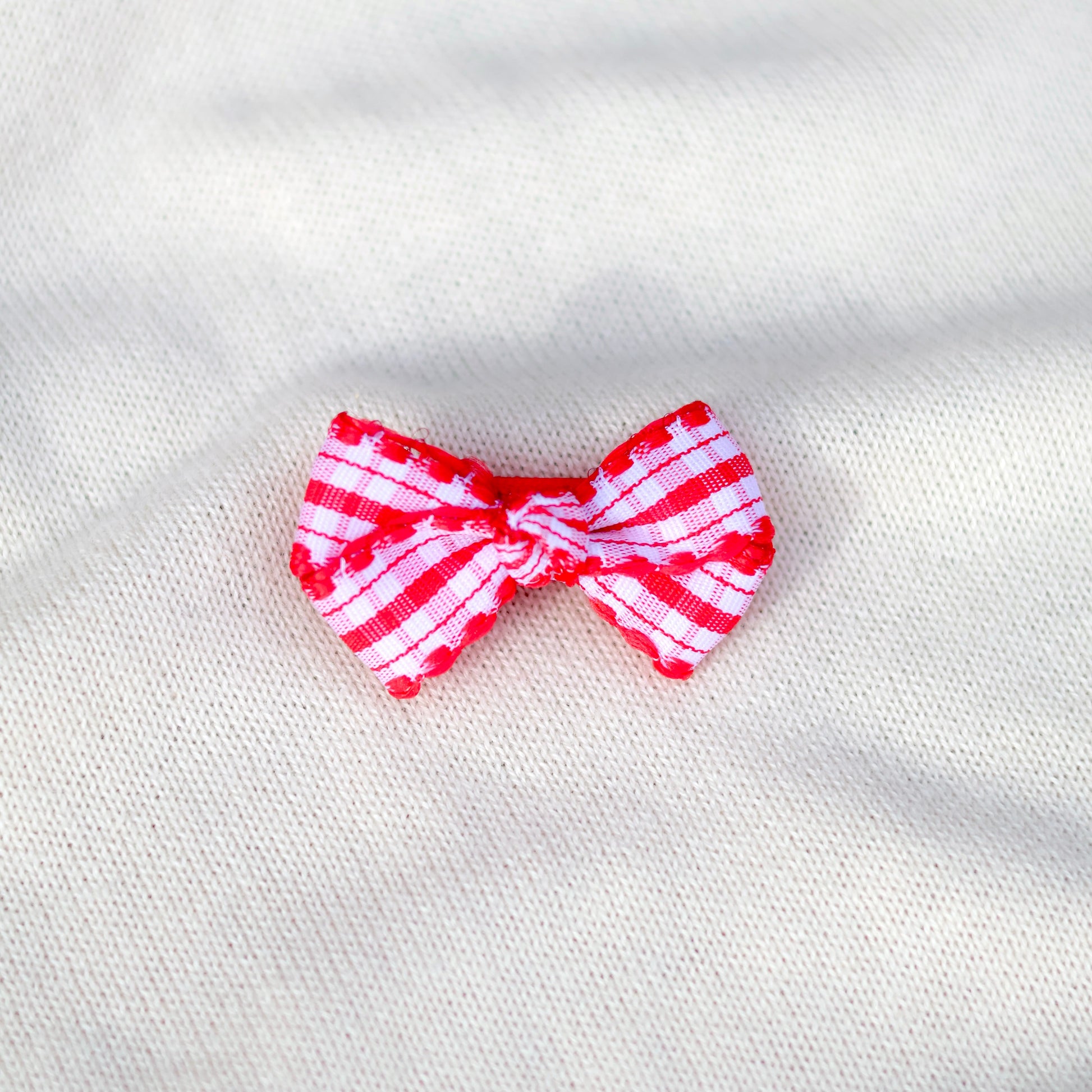 Red and white striped bow on a textured white background