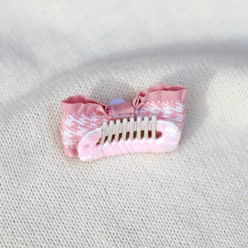 Pink hair clip on a textured white surface