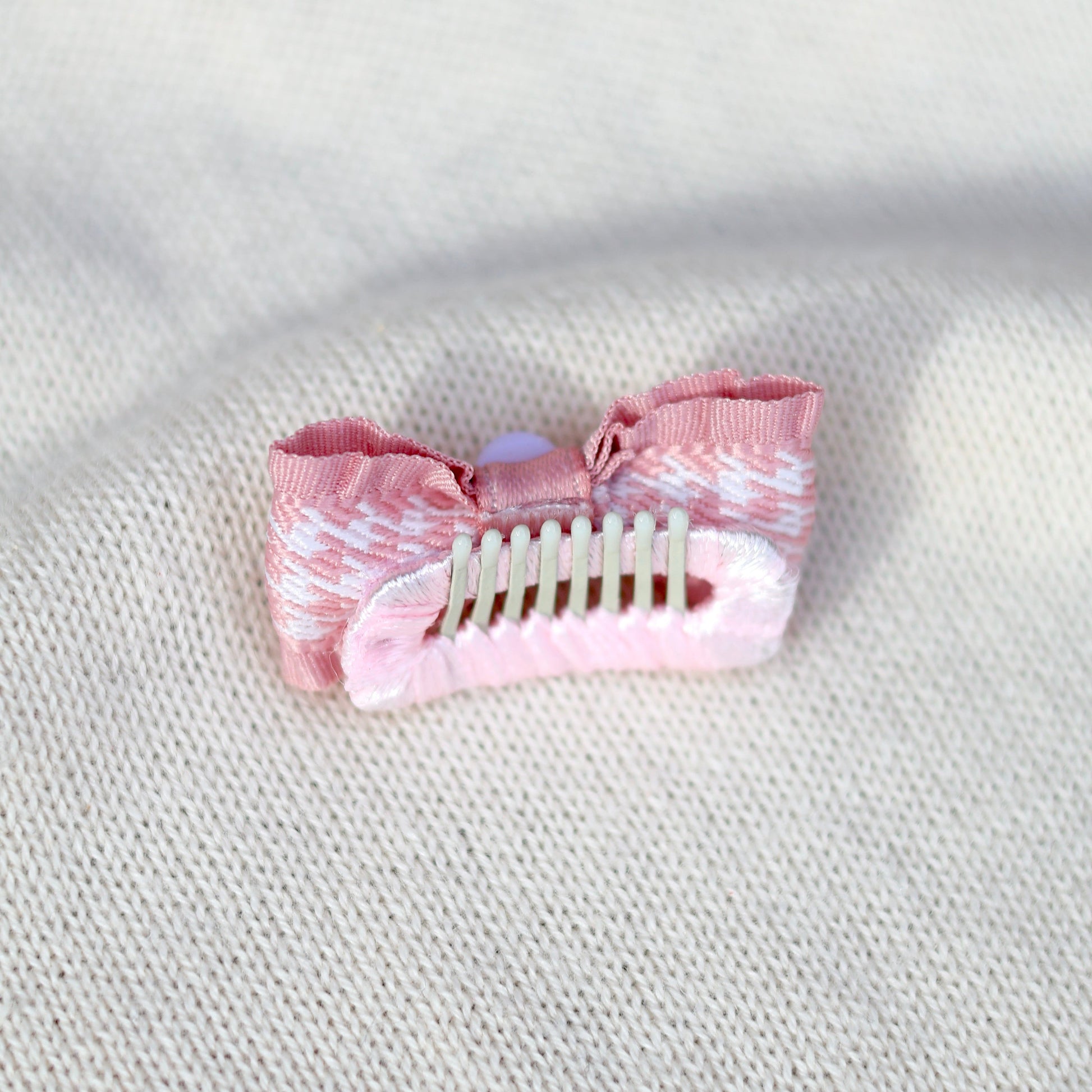 Pink hair clip on a textured white surface