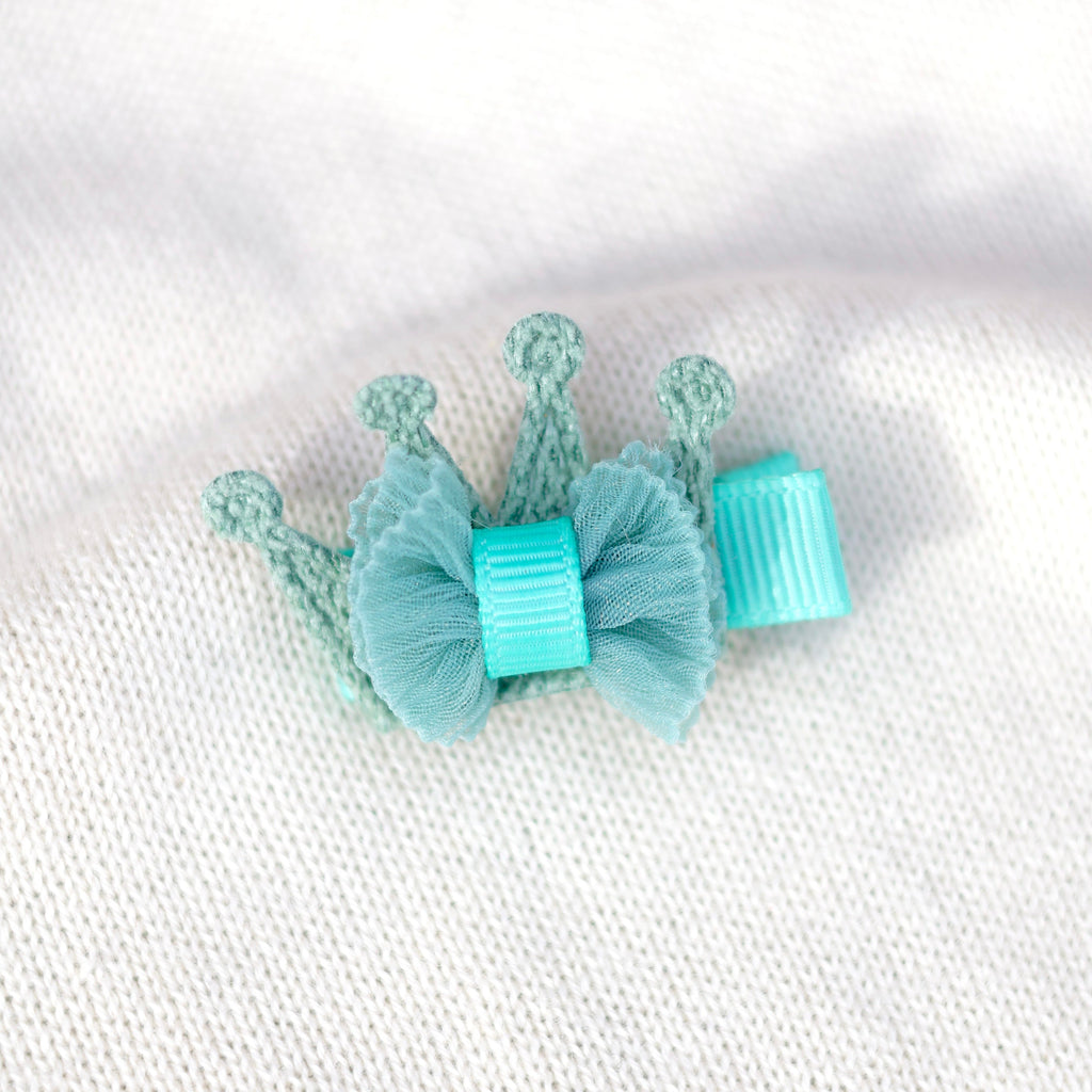 Pair of light blue butterfly clip earrings on a textured white background