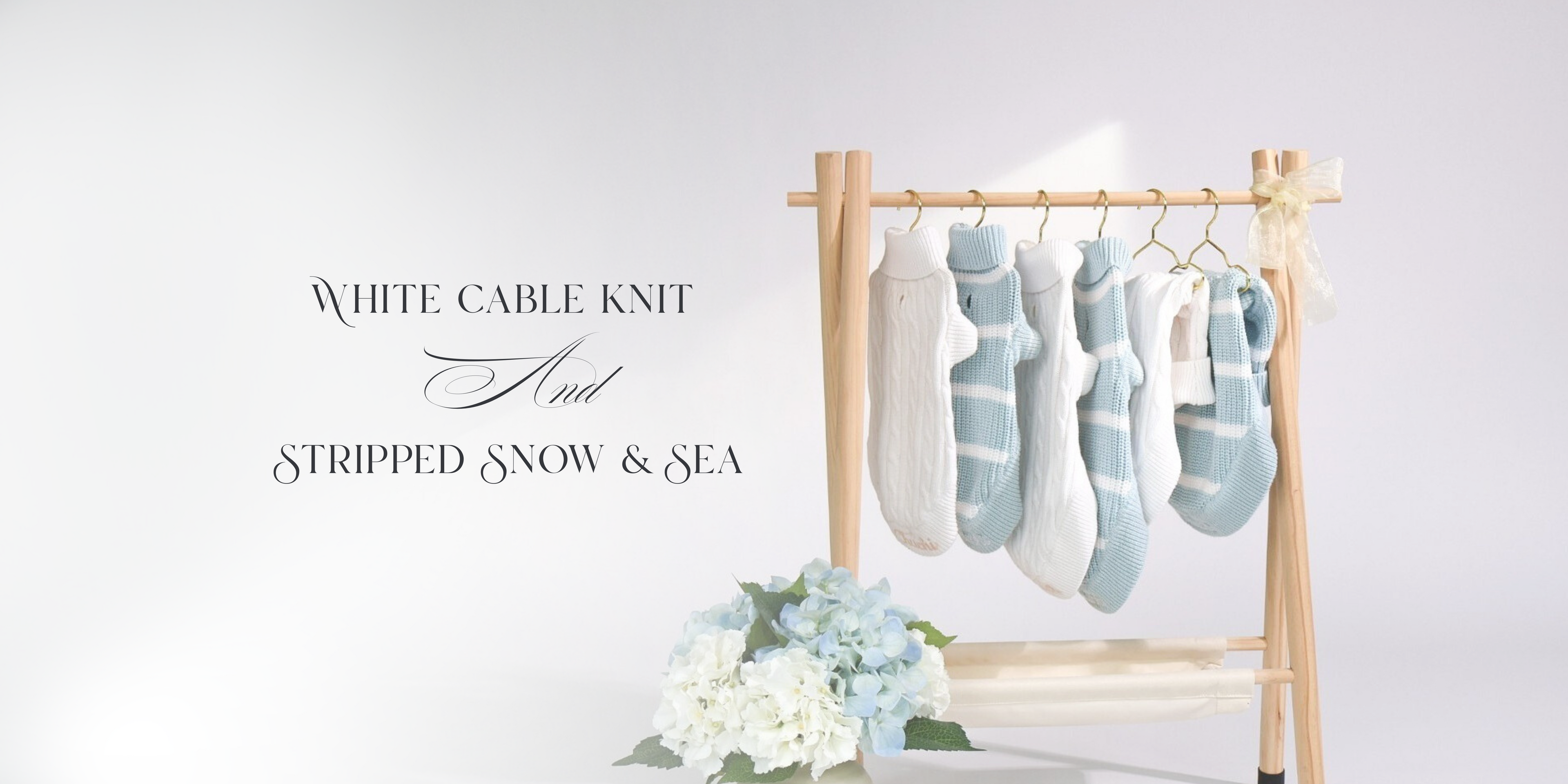 Rack with white and light blue cable knit dog sweater on a white background
